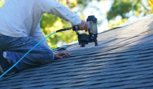 Contractor installing roof shingles as part of expert roofing services in New York.