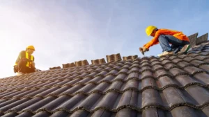 Worker repairing a chimney on a tiled roof, representing Paragon’s expert roofing services in New York.