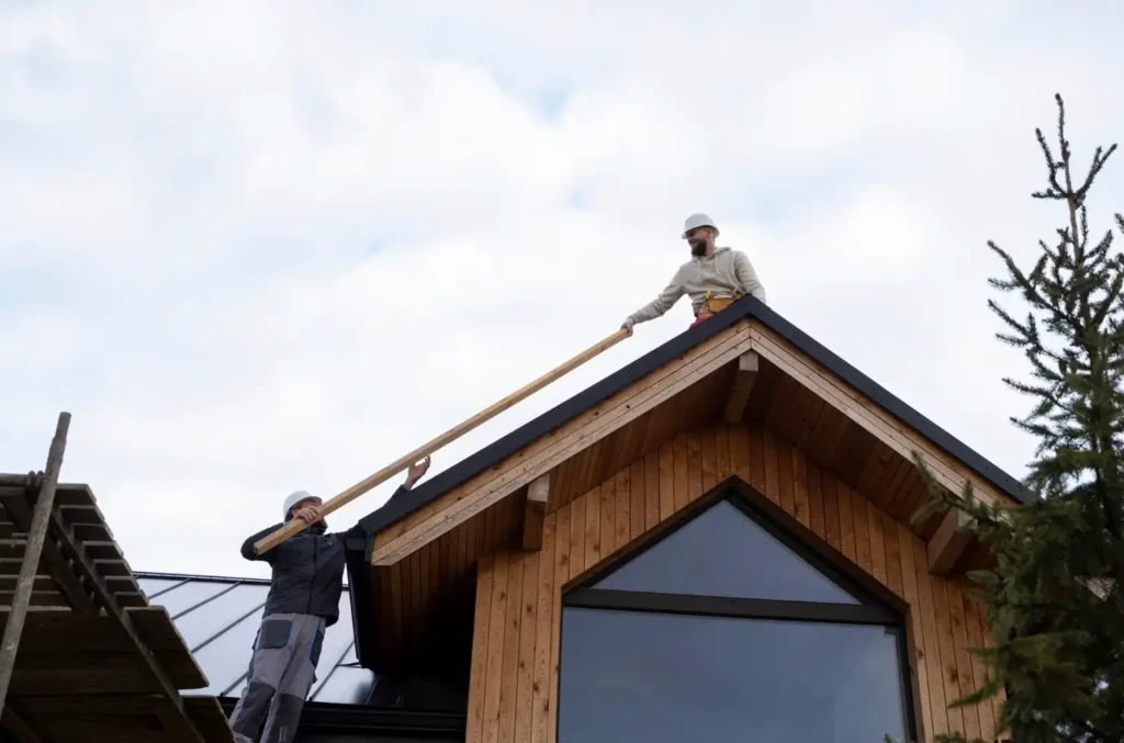 Roofing contractors working on a wooden house roof, demonstrating Flatbush Roofing installation services for residential properties.