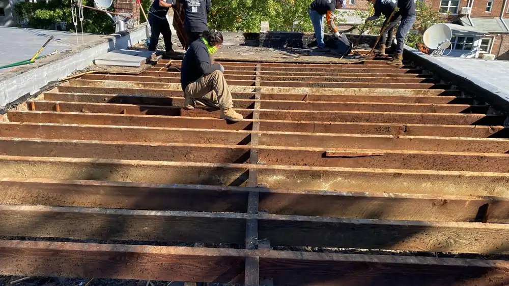 Roofing crew replacing flat roof structure, showing prep work for best roof style for home renovation.