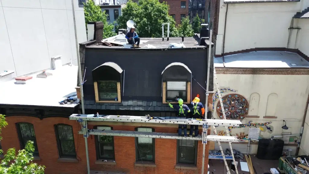 Workers installing new roofing materials on a building, showcasing the process of selecting the best roofing materials for durability and aesthetics.