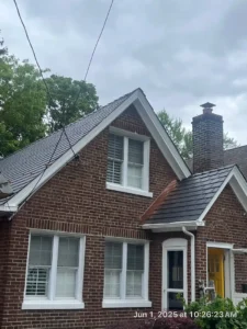 Newly installed slate roofing on a brick house with a chimney, showcasing quality roofing services by Paragon Chimney and Roofing in New York.