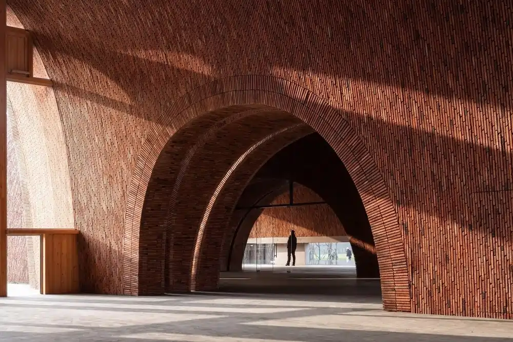 Curved brick masonry structure showcasing architectural masonry examples in a modern public space.