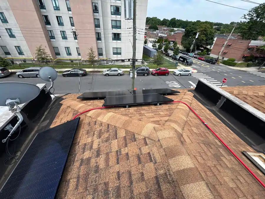 Solar panels installed on an asphalt shingle roof, demonstrating optimal setup and modern energy efficiency for residential roofing replacement frequency.